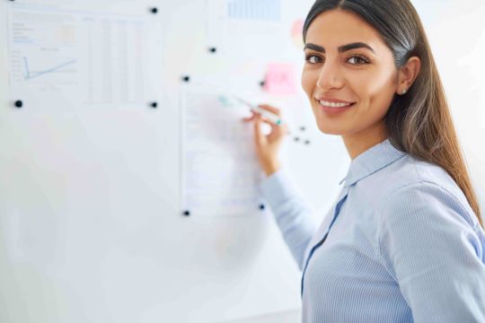 Female teacher writing on white board