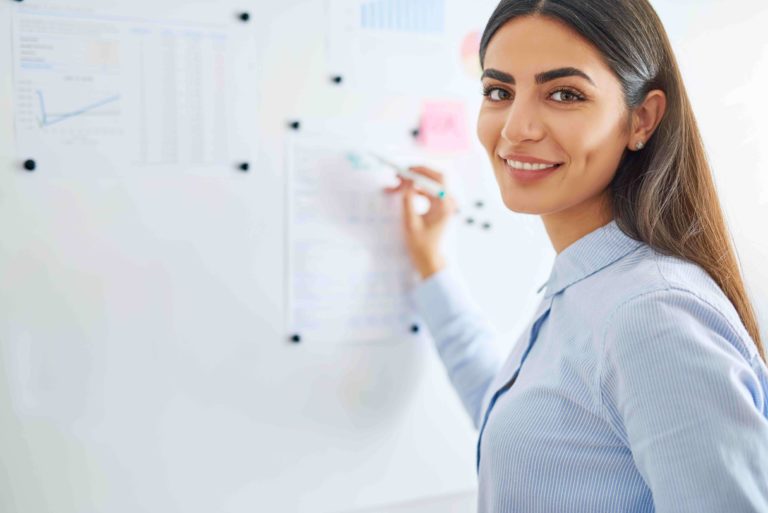 Female teacher writing on white board