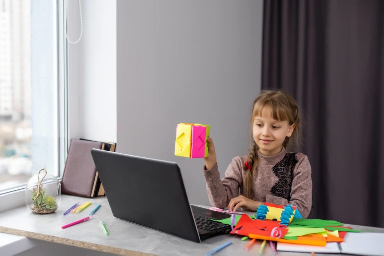 Young student creating art and sharing it on a laptop.