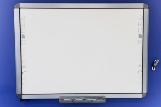 A smart board on the wall of a classroom.