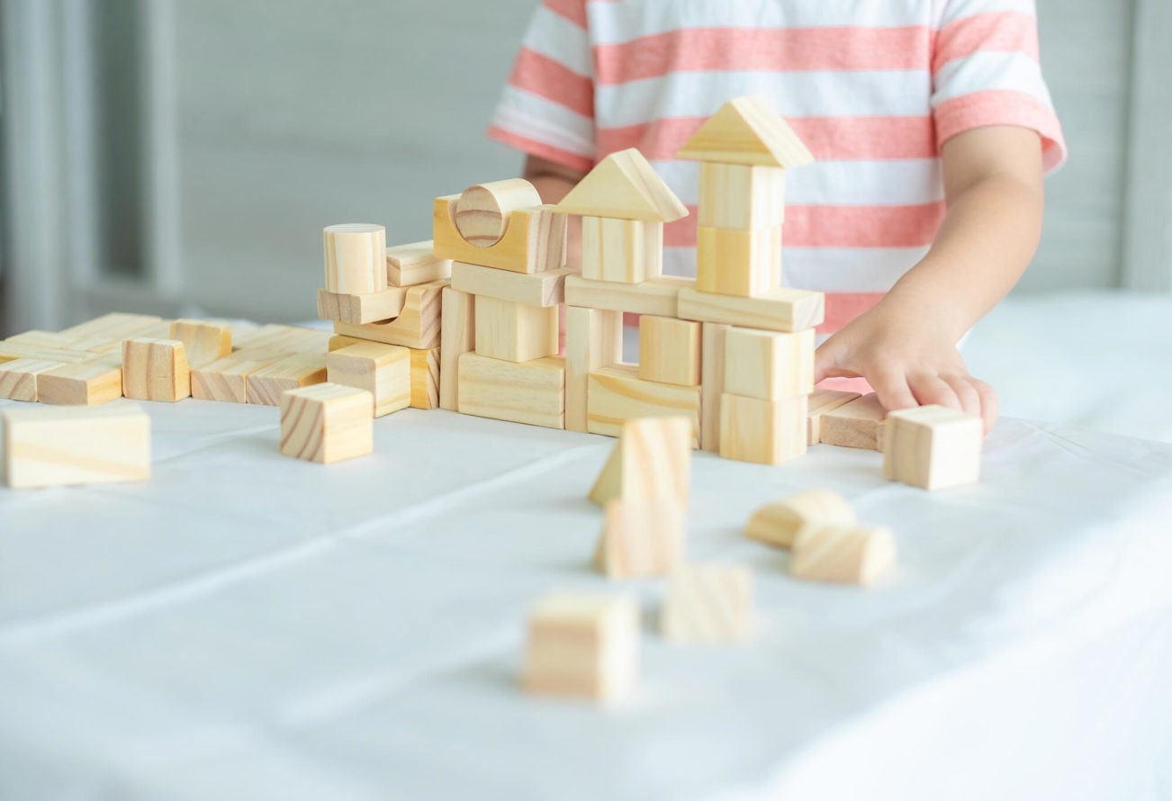 Close up of young boy building a house with blocks