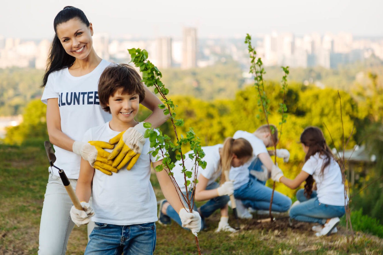 Woman volunteer embracing her child helper