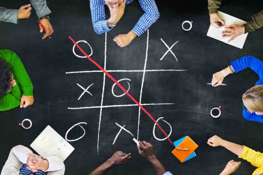 Arial view of a group of students sitting around a table playing a game.