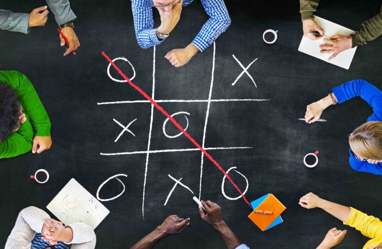 Arial view of a group of students sitting around a table playing a game.