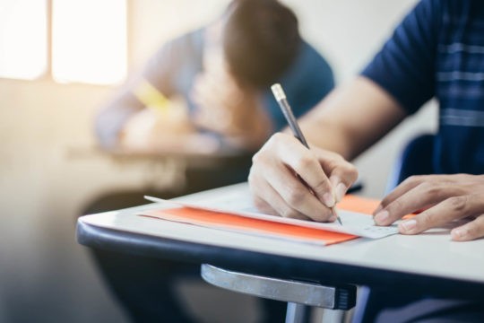 Student sitting at a desk in a classroom taking a test.