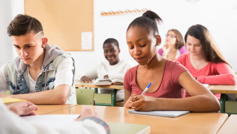 Classroom full of young students writing at their desks.