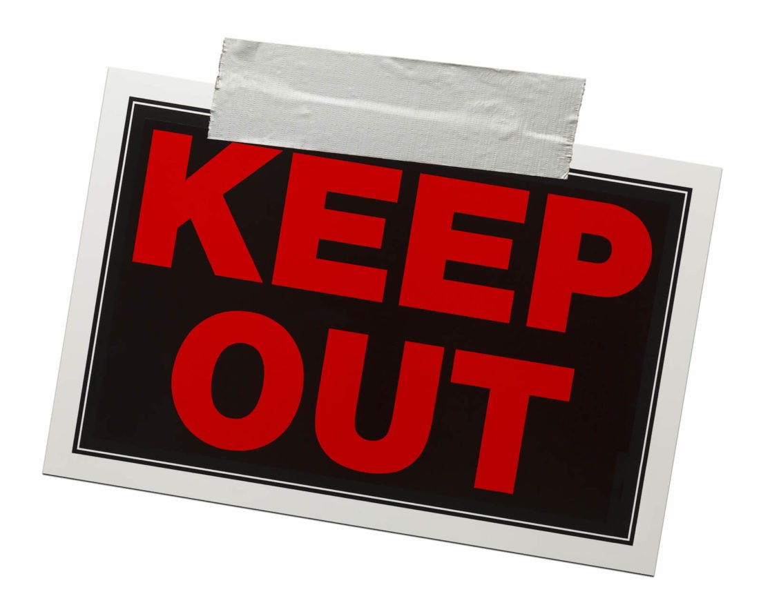 A red and black ‘Keep Out’ sign with duct tape holding it up
