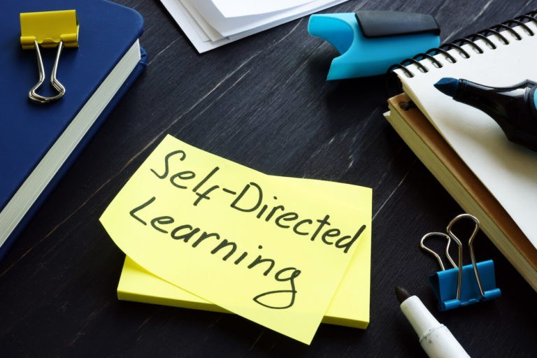 ‘Self-Directed Learning’ written on a post-it note surrounded by office supplies.