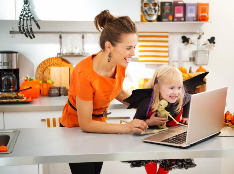 Young girl and her mom dressed up for Halloween on a video call.