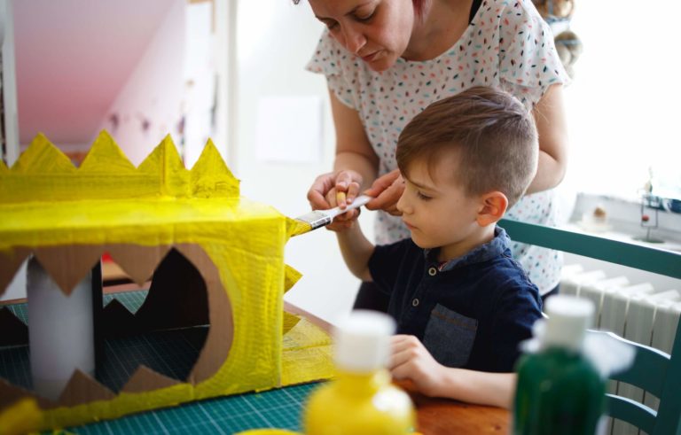 Mother and young son working on a craft project together.