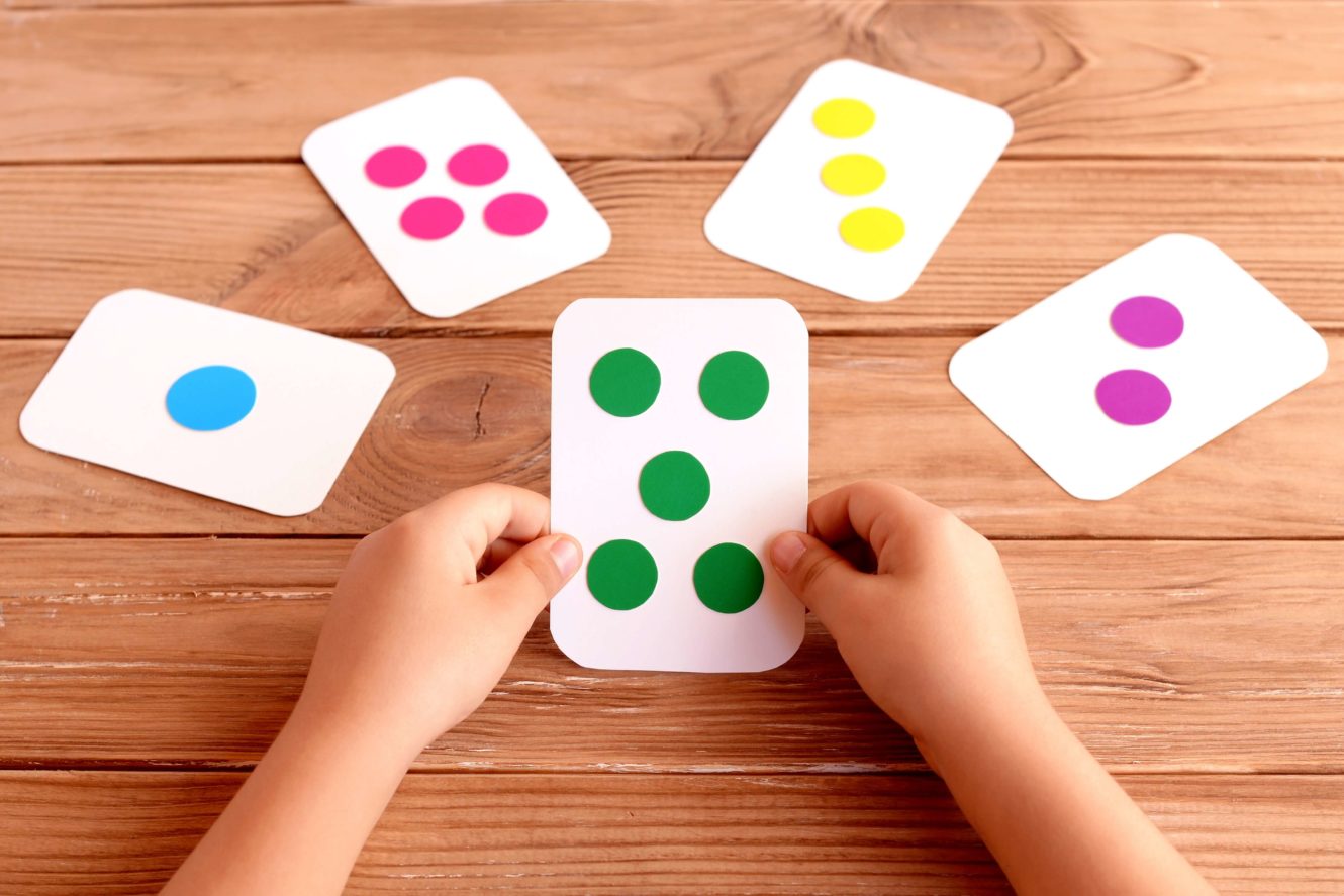 Student holding flash card with five colored circles