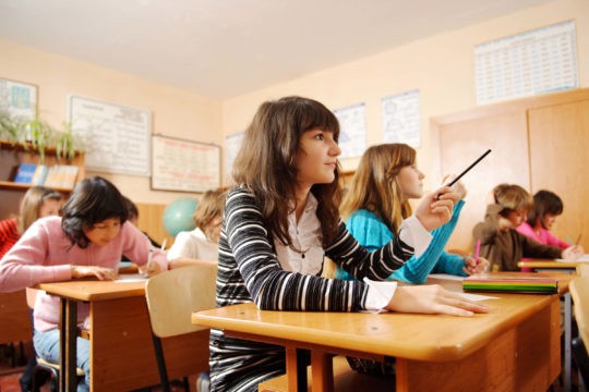 Students sitting in desks learning in classroom