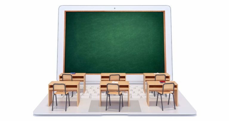 Open laptop with a blackboard as the screen and desks on the keyboard.